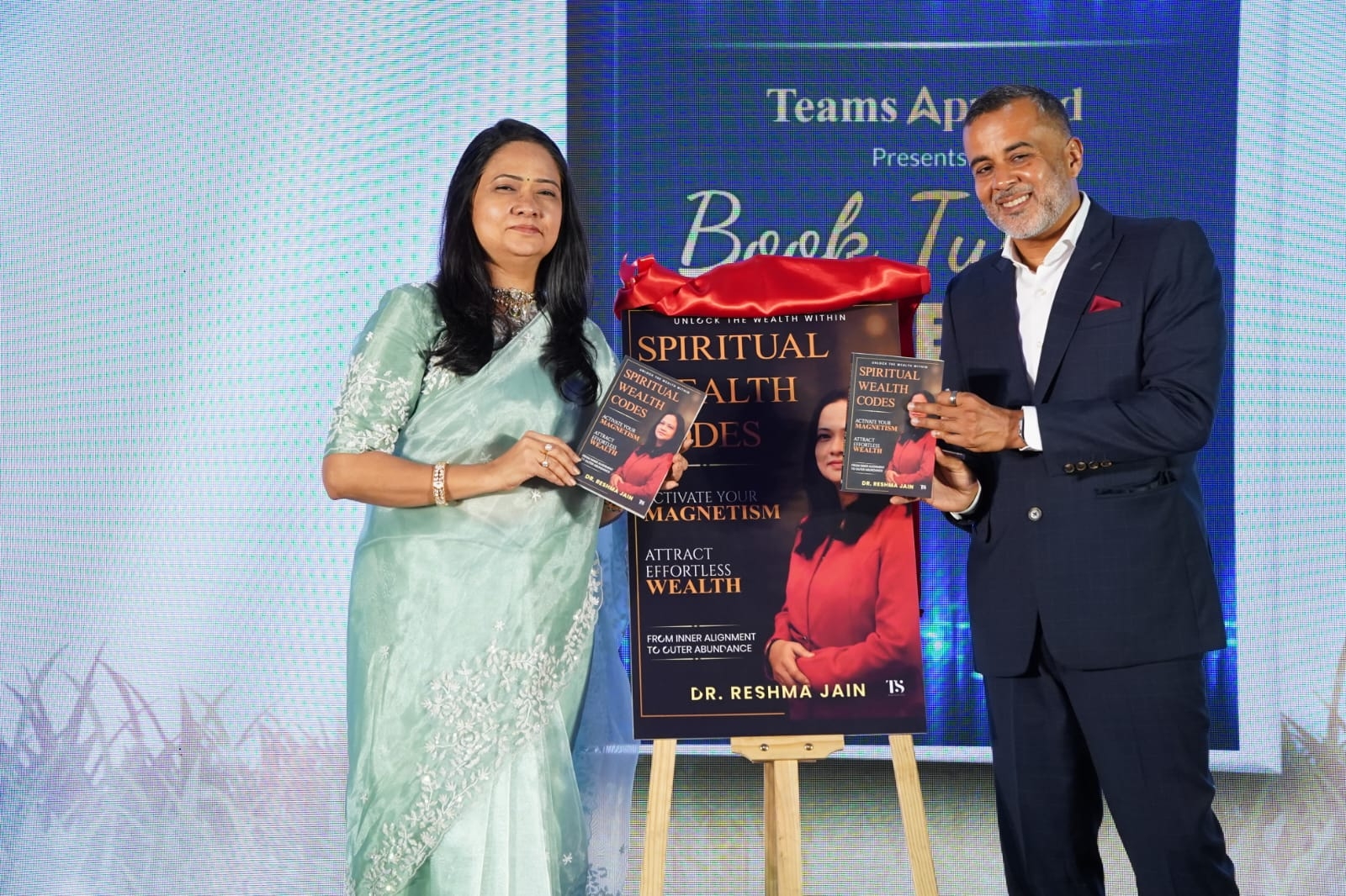 Dr. Reshma Jain unveiling Spiritual Wealth Codes on stage with bestselling author Chetan Bhagat