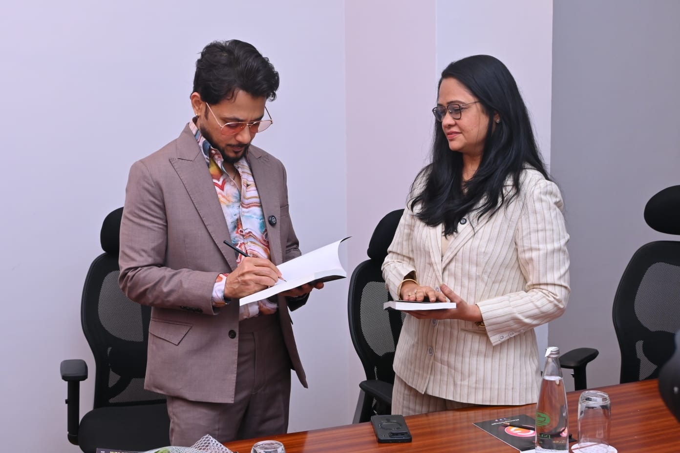 Anupam Mittal signing a copy of Spiritual Wealth Codes with Dr. Reshma Jain